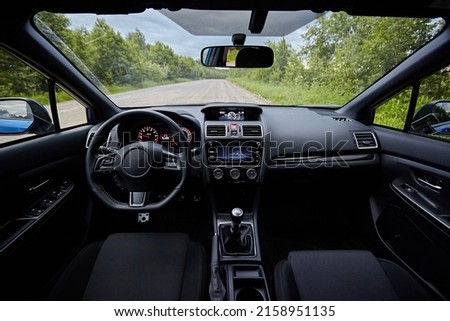 Dark car interior - steering wheel, shift lever and dashboard. Car modern inside. Front view  Royalty-Free Stock Photo #2158951135
