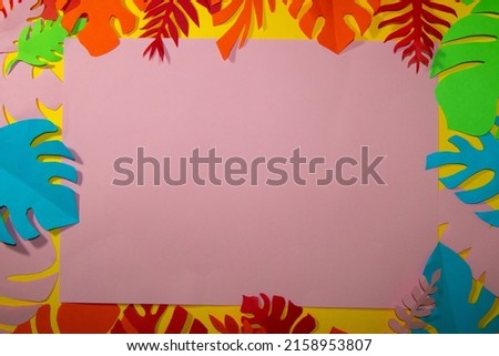 pink background for copy space surrounded by colorful jungle leaves, creative summer tropical design, flat lay