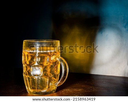 Mug of beer and its colorful shadow Royalty-Free Stock Photo #2158963419