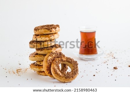 Traditional Turkish Kandil,Sesame Rings stacked with tea on white surface.
