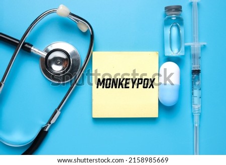 A picture of notepad written monkeypox, stethoscope ,medicine and vaccine. Monkeypox is virus transmitted to humans from animals with symptoms very similar to smallpox.  Royalty-Free Stock Photo #2158985669
