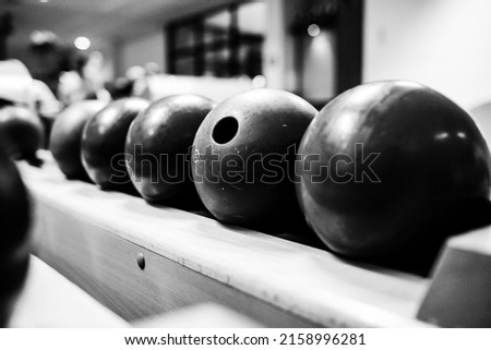 A grayscale closeup shot of bowling balls on the playground