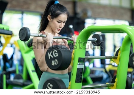 Asian woman weightlifter preparing for training, Asian woman workout weightlifting in weight training fitness gym, sport exercise and muscular build, Healthy lifestyle. Royalty-Free Stock Photo #2159018945