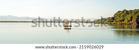 Nosy Be, Madagascar  Traditional sailing boat and canoe sail out on the Indian Ocean from Port Ankify, Ambanja district, Northern Madagascar  Royalty-Free Stock Photo #2159026029