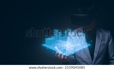 A young Asian man wearing virtual reality glasses and holding a 3D rendered city layout