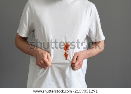 sauce dirty stain spot on the clothes, white t-shirt issue Royalty-Free Stock Photo #2159051291