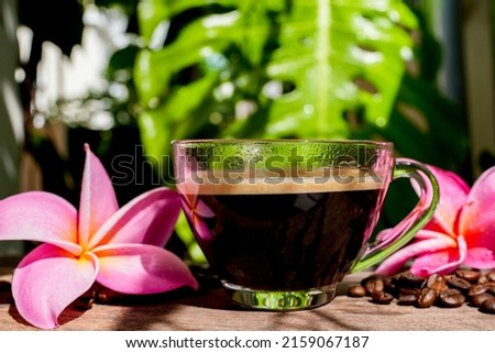 Cup Black Coffee On Wooden Table In Morning Against Monstera Leaf Background.