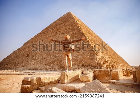 Travel man in hat stand background Egyptian pyramid sunset Giza Cairo, Egypt. Royalty-Free Stock Photo #2159067241