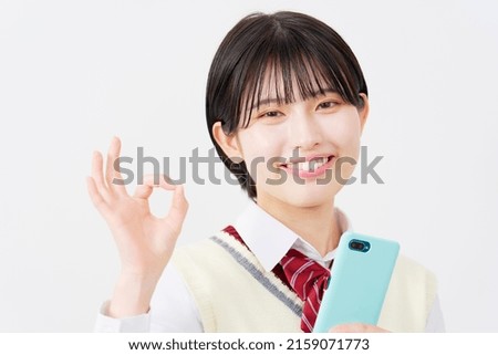 Asian high school student OK gesture with the smartphone in white background
