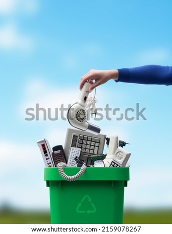 Woman putting an old broken appliance in the trash bin, e-waste and recycling concept Royalty-Free Stock Photo #2159078267