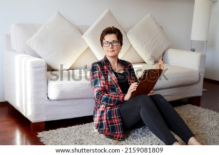 Portorož, Slovenia. 05.11.2022. Lifestyle portrait of happy business woman in casual clothes relaxing, sitting on couch at cozy home with laptop. Drinking coffee. Working from home. Online shopping