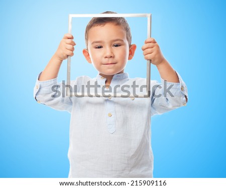 portrait of a little boy looking through an empty frame
