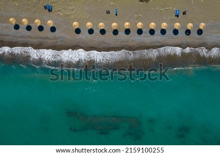 Drone aerial landscape of beach umbrellas in a row.