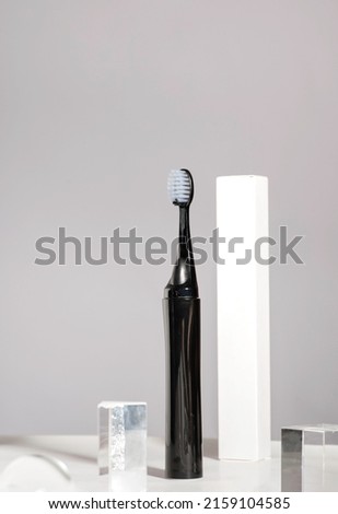 Modern rechargeable toothbrush with copy space on grey background