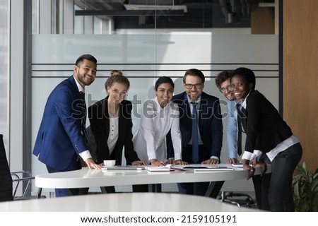 Company professional successful staff members portrait concept. Six multi ethnic young, ambitious employees gather in boardroom, working together take part in seminar meeting smile staring at camera Royalty-Free Stock Photo #2159105191