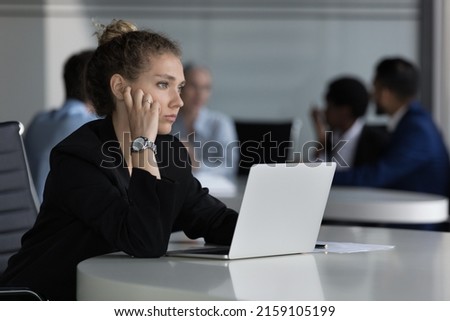 Young thoughtful woman sit at desk with laptop looks into distance feels unmotivated or unsure working on on-line task, experiences problem with solution. Challenge, corporate office workflow concept Royalty-Free Stock Photo #2159105199