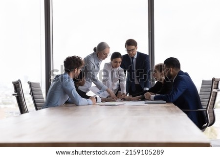 Team of professional diverse business people discuss financial report in charts, diagrams, graphs, analysing sales statistics and deal benefits at group meeting in modern board room, teamwork concept Royalty-Free Stock Photo #2159105289