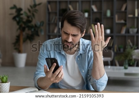 Telephone problem. Upset angry millennial male feel outraged by bad wrong work of smartphone app poor weak wifi signal. Worried nervous young man missed business phone call get too much spam messages Royalty-Free Stock Photo #2159105393