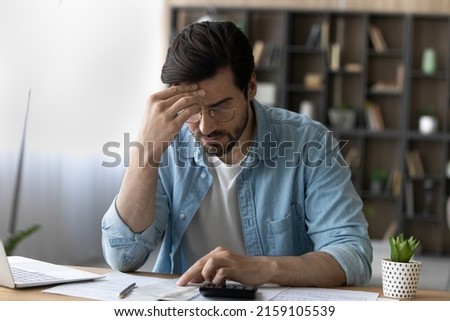 Financial problem. Concerned millennial businessman calculate taxes bills payments deal with debt bankruptcy overdue account. Worried young man accountant unable to form balance sheet look for mistake Royalty-Free Stock Photo #2159105539