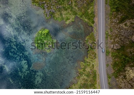 An aerial shot of a road near a lake