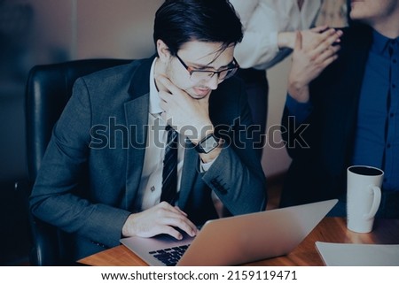 Young serious  professional business man, focused male student wearing glasses working on laptop