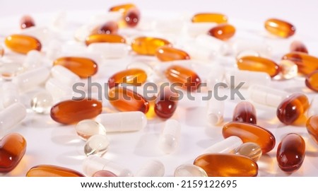 Various white, orange and transparent Capsules isolated on white Background - Healthy Nutrition
