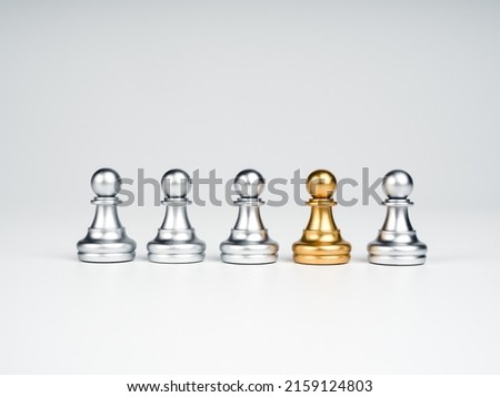 The golden pawn chess piece standing out of the group of silver pawn chess pieces on white background, stand out from the crowd. Leadership, Unique, influencer, difference concept. Royalty-Free Stock Photo #2159124803