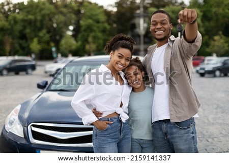 New Car. Happy Black Family Showing Own Automobile Key To Camera Standing Near Auto Posing Outdoor. Vehicle Purchase And Rent, Dealership Advertisement Concept Royalty-Free Stock Photo #2159141337