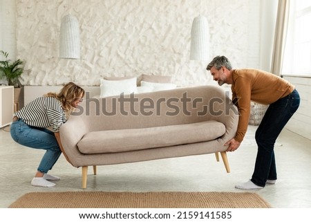 Happy Couple Putting Sofa Together After Renovation At Home. Husband And Wife Furnishing Their Living Room And New House. Modern Furniture And Interior Design Concept Royalty-Free Stock Photo #2159141585