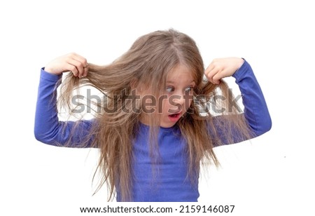 Isolated caucasian little girl of 5 6 years holding hair being in shock about hair losing or having lice on white background