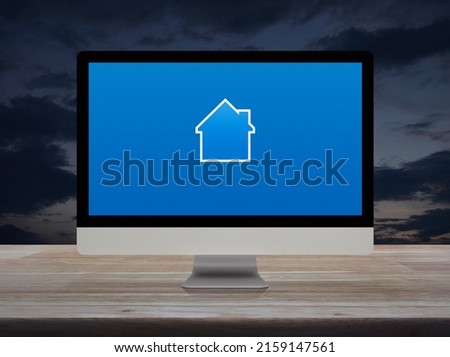 House icon with copy space on desktop modern computer monitor screen on wooden table over sunset sky, Business real estate online concept
