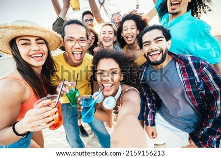 Multi-ethnic group of friends making beach party toasting cocktail glasses together - Guys and girls hanging outside taking selfie picture on summer vacation - Spring break, summertime holiday concept