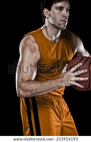 Basketball player on a  orange uniform, on a black background.