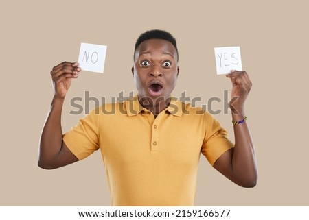 Portrait man with YES NO sticky post it note cards and funny face expression choosing between two opposites uncertain unsure about difficult life choice, overwhelmed by inner conflict or moral dilemma Royalty-Free Stock Photo #2159166577