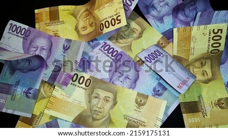 5,000 and 10,000 rupiah banknotes isolated on a black background. Rupiah currency, Indonesian economic concept.