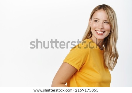 Portrait of happy modern woman, beautiful girl with white smile, bloind hair and clear natural skin without makeup, standing over white background