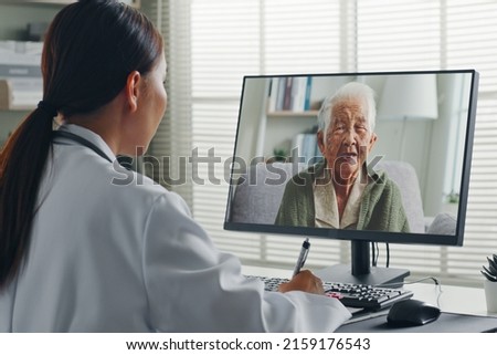 Female Asian doctor making video call with Asian senior woman grey hair 80-90s, telemedicine telehealth concept Royalty-Free Stock Photo #2159176543