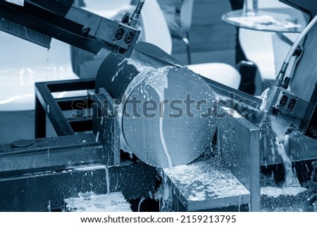 The automatic band saw machine cutting the metal rod  with water base coolant method. The machine tool for industrial purpose. Royalty-Free Stock Photo #2159213795