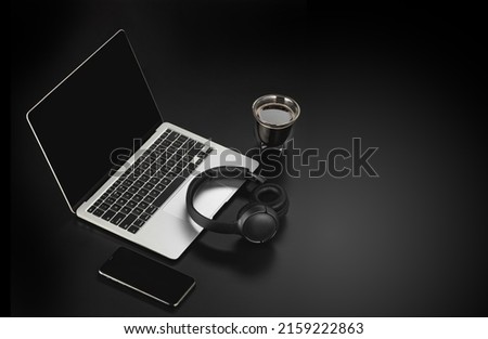 Workspace mockup template  on black background. Musician composer workplace with headphones, laptop, phone and cup of coffee
