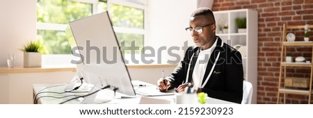 Young Male Designer Editing Photos On Computer In Office