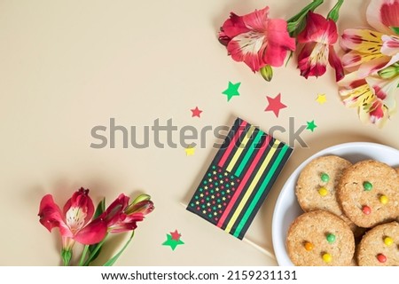 creative background for Juneteenth day with Black Liberation African American flags, tea cakes cookie and bright flowers