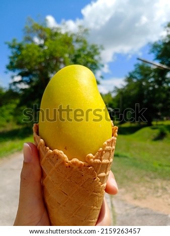 hand holding ice cream cone, Mango ice cream in summer concept