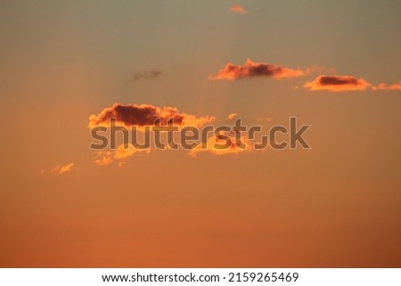 A beautiful view of an orange sky with clouds