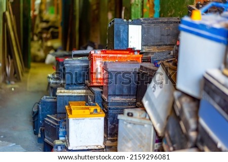 Discarded old car batteries in a garage for recycling in a lead scrap yard. Selective focus. Royalty-Free Stock Photo #2159296081