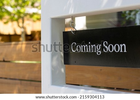 Closeup of a "Coming Soon" real estate sign outside a residential single-family house. Housing market inventory concept.