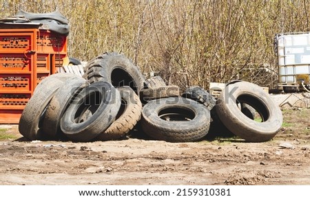 Changing car tires. Old rubber tires in the trash. Car dump. Garbage for recycling. Royalty-Free Stock Photo #2159310381