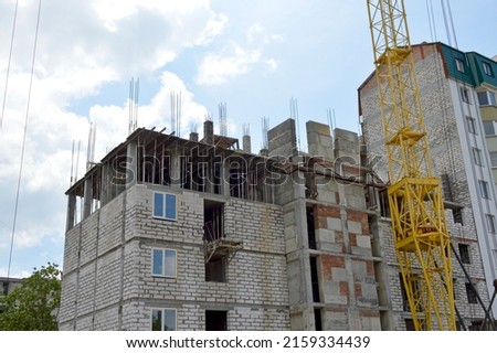 construction of a multi-storey residential building in an urban area. on the photo is a tower crane and the unfinished upper floors of the building