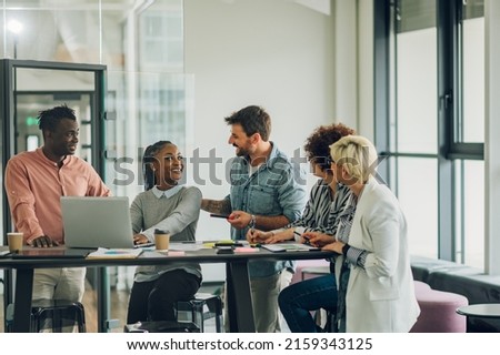Startup multiracial business team on a meeting in a modern bright office interior. Woman team leader present project to her diverse colleagues. Royalty-Free Stock Photo #2159343125