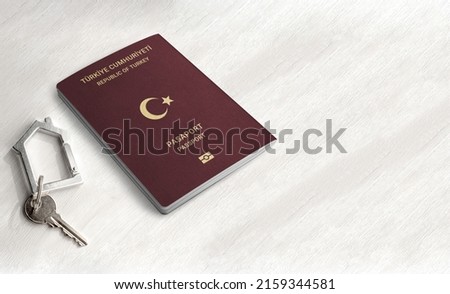 Turkish passport citizenship by real estate investment ,Passport and home key on a wood table ,Space for writing Royalty-Free Stock Photo #2159344581