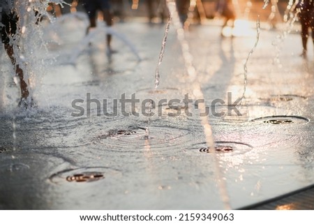 street dancing fountains, fountain jets in the evening light, hot summer and water jets